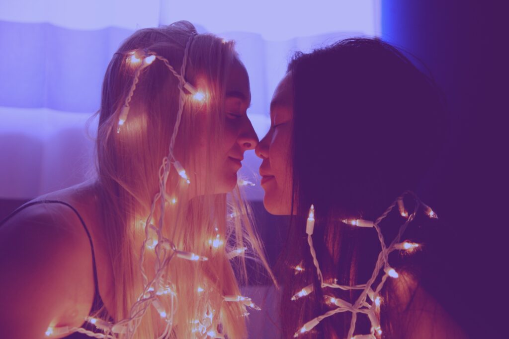 two women lean in to kiss each other